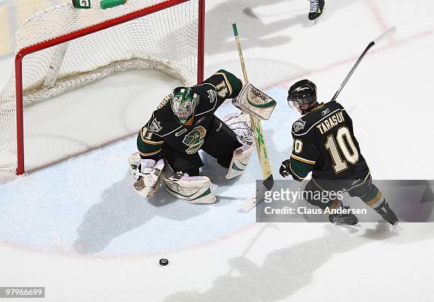 Michael Hutchinson and Steven Tarasuk of the London Knights try to cover a loose puck in the first game of the opening round of the 2010 playoffs...