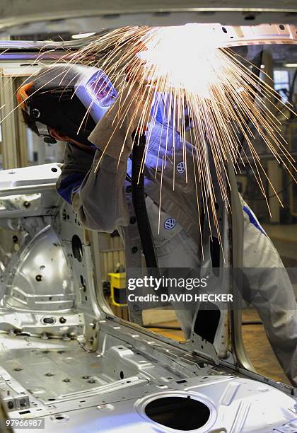 An employee of German car manufacturer Volkswagen works on a car body of a VW Golf on March 8, 2010 in Wolfsburg, northern Germany. Volkswagen holds...