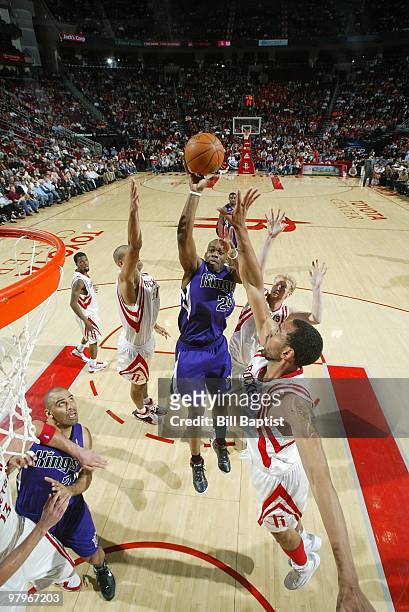 Carl Landry of the Sacramento Kings shoots against Shane Battier, Chase Budinger and Jared Jeffries of the Houston Rockets during the game on March...