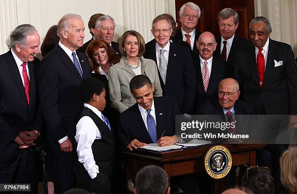 President Barack Obama signs the Affordable Health Care for America Act during a ceremony with fellow Democrats in the East Room of the White House...