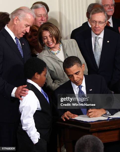 President Barack Obama signs the Affordable Health Care for America Act during a ceremony with fellow Democrats in the East Room of the White House...