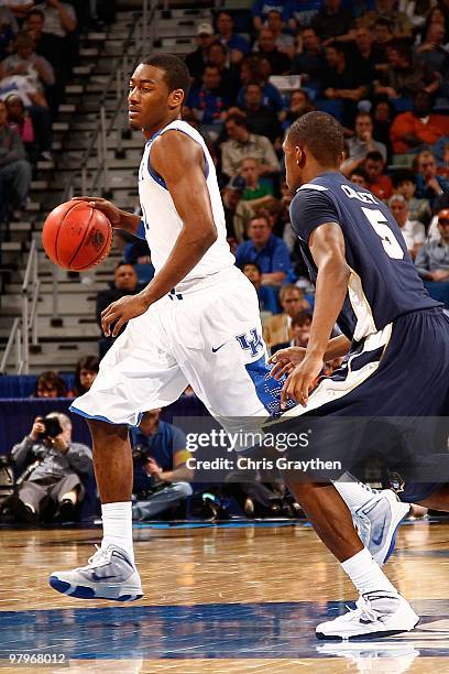 John Wall of the Kentucky Wildcats drives the ball around Sheldon Cooley of the East Tennessee State Buccaneers during the first round of the 2010...