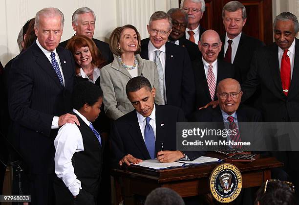 President Barack Obama signs the Affordable Health Care for America Act during a ceremony with fellow Democrats in the East Room of the White House...