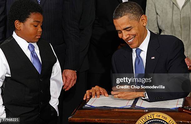 President Barack Obama signs the Affordable Health Care for America Act as Marcelas Owens looks on during a ceremony with fellow Democrats in the...