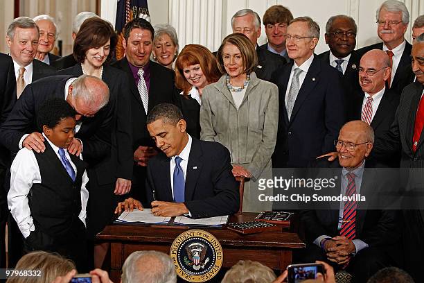President Barack Obama signs the Affordable Health Care for America Act during a ceremony with fellow Democrats in the East Room of the White House...