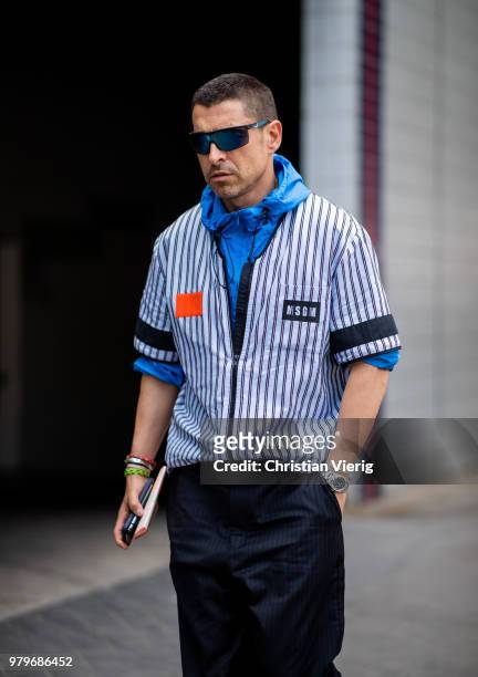 Alex Badia wearing blue white striped MSGM button shirt seen outside Acne on day two of Paris Fashion Week Menswear SS19 on June 20, 2018 in Paris,...