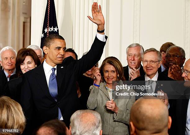 President Barack Obama waves after signing the Affordable Health Care for America Act during a ceremony with Rep. Sandy Levin , Victoria Kennedy,...