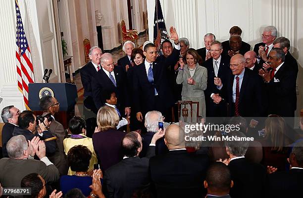 President Barack Obama is applauded after signing the Affordable Health Care for America Act during a ceremony with fellow Democrats in the East Room...