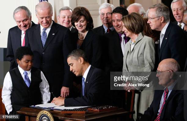 President Barack Obama signs the Affordable Health Care for America Act during a ceremony with fellow Democrats in the East Room of the White House...