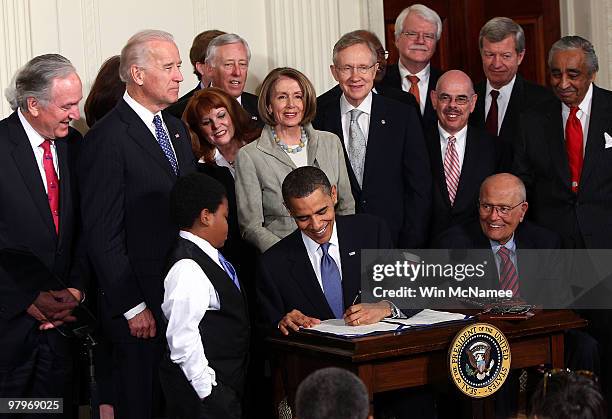 President Barack Obama signs the Affordable Health Care for America Act during a ceremony with fellow Democrats in the East Room of the White House...