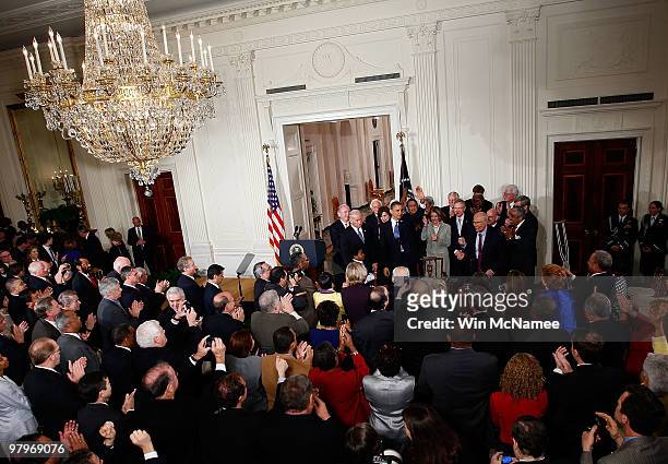 President Barack Obama is applauded after signing the Affordable Health Care for America Act during a ceremony with fellow Democrats in the East Room...
