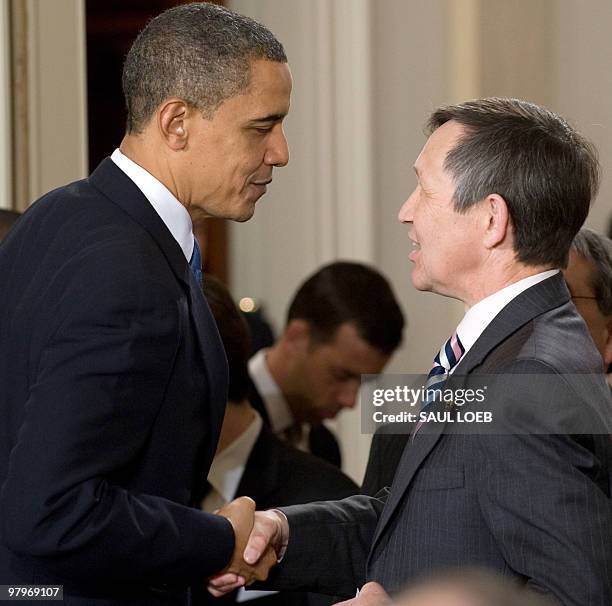 President Barack Obama shakes hands with Ohio Democratic Representative Dennis Kucinich after signing the healthcare insurance reform legislation...