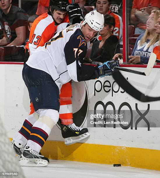 Dan Carcillo of the Philadelphia Flyers battles along the boards with Pavel Kubina of the Atlanta Thrashers on March 21, 2010 at the Wachovia Center...