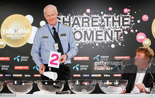 Kare Stolen , head of the Gronland Oslo Police Station, flanked by Svante Stockselius , head of the Eurovision Song Contest, displays the number '2'...