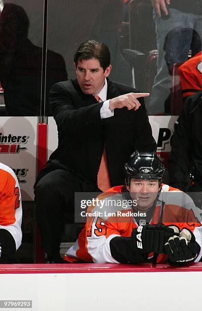 Head Coach Peter Laviolette and Arron Asham of the Philadelphia Flyers look on from the bench against the Atlanta Thrashers on March 21, 2010 at the...