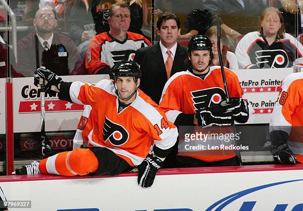 Ian Laperriere, Head Coach Peter Laviolette and Dan Carcillo of the Philadelphia Flyers watch the play develop from the bench against the Atlanta...