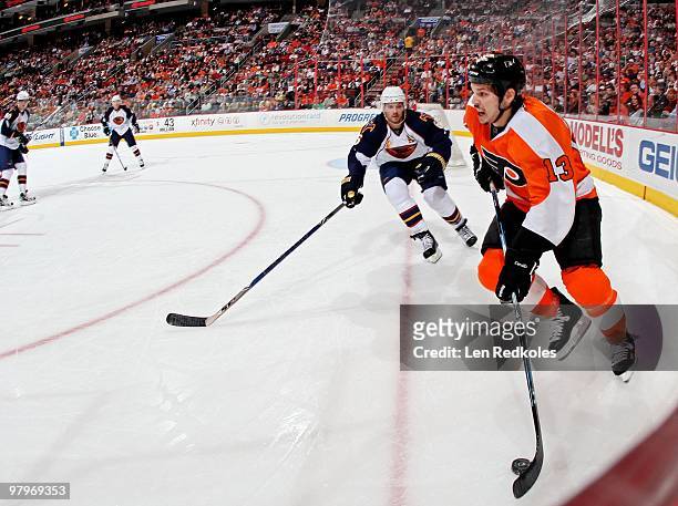 Dan Carcillo of the Philadelphia Flyers skates the puck over the goal line against Ron Hainsey of the Atlanta Thrashers on March 21, 2010 at the...