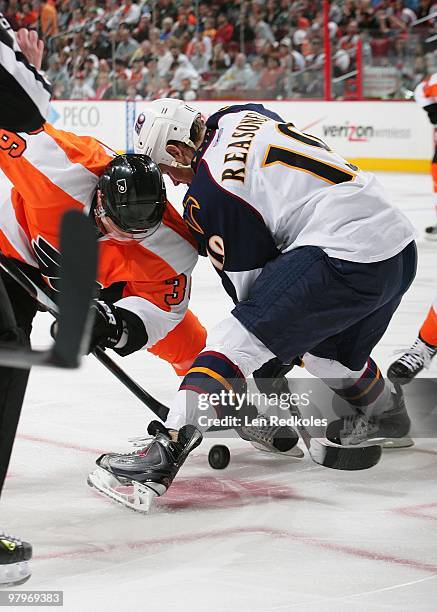 Darroll Powe of the Philadelphia Flyers battles for the puck on a face-off against Marty Reasoner of the Atlanta Thrashers on March 21, 2010 at the...