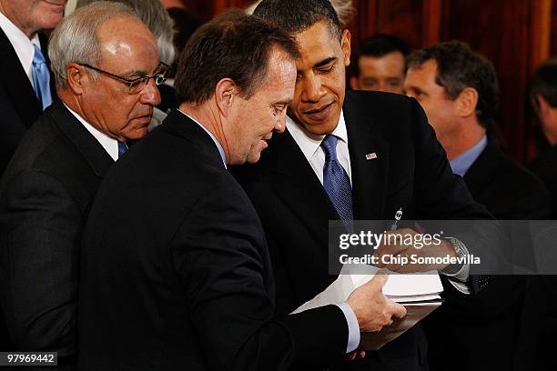 President Barack Obama signs a copy of the Affordable Health Care for America Act for a member of Congress after signing the acutual bill during a...