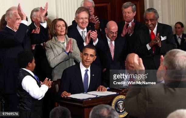 President Barack Obama is applauded after signing the Affordable Health Care for America Act during a ceremony with fellow Democrats in the East Room...