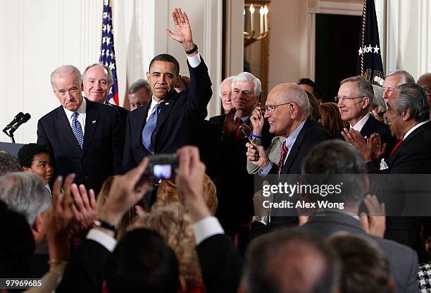 President Barack Obama waves after he signed the Affordable Health Care for America Act during a ceremony with fellow Democrats in the East Room of...