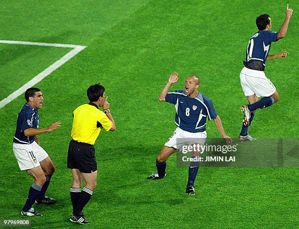 Midfielder Claudio Reyna and US forward Earnie Stewart protest to referee Lu Jun of China about a disallowed goal early in their Group D match...