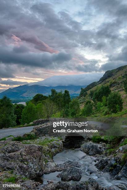 clouds over stone ashness bridge, skiddaw in background, lake district, cumbria, england, uk - montanhas cumbrianas - fotografias e filmes do acervo