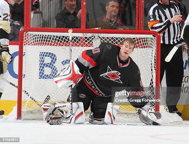 Justin Peters of the Carolina Hurricanes loses his helmet after a collision in the crease during a NHL game against the Pittsburgh Penguins on March...