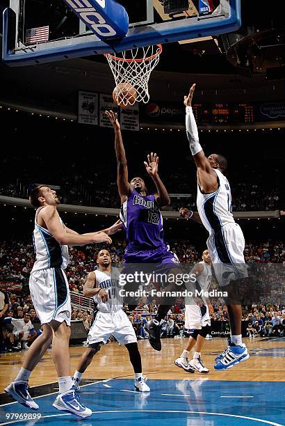 Tyreke Evans of the Sacramento Kings lays the ball up over Ryan Anderson, Jameer Nelson and Dwight Howard of the Orlando Magic during the game on...