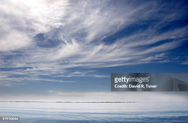 wispy clouds over a calm lake ontario - 巻雲 ストックフォトと画像