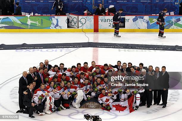 Team Canada poses for a team group photo with their gold medals after winning the ice hockey men's gold medal game against USA as Zach Parise and...