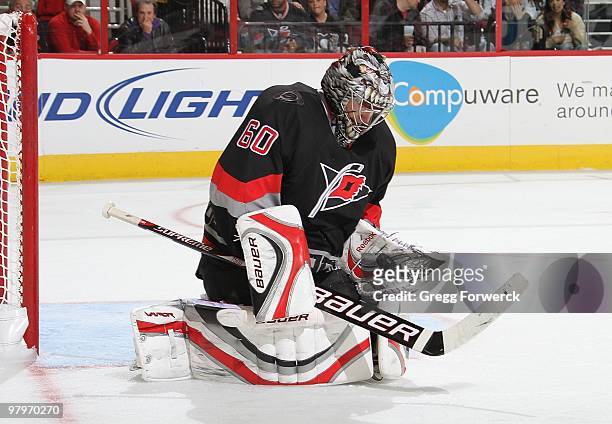 Justin Peters of the Carolina Hurricanes makes a glove save during a NHL game against the Pittsburgh Penguins on March 11, 2010 at RBC Center in...