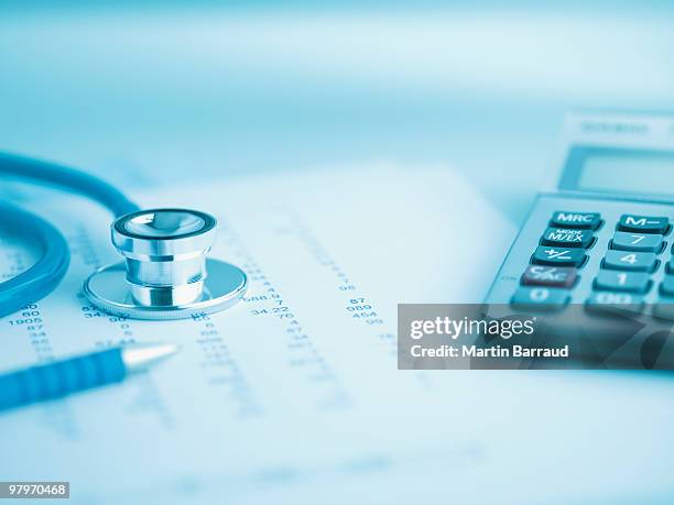 close up of calculator, data and stethoscope - insurance foto e immagini stock