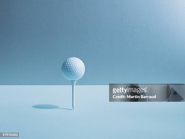 golf ball balancing on tee - golf tee stock pictures, royalty-free photos & images