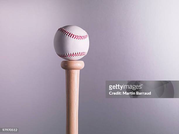 baseball balancing on bat - dinge die zusammenpassen stock-fotos und bilder
