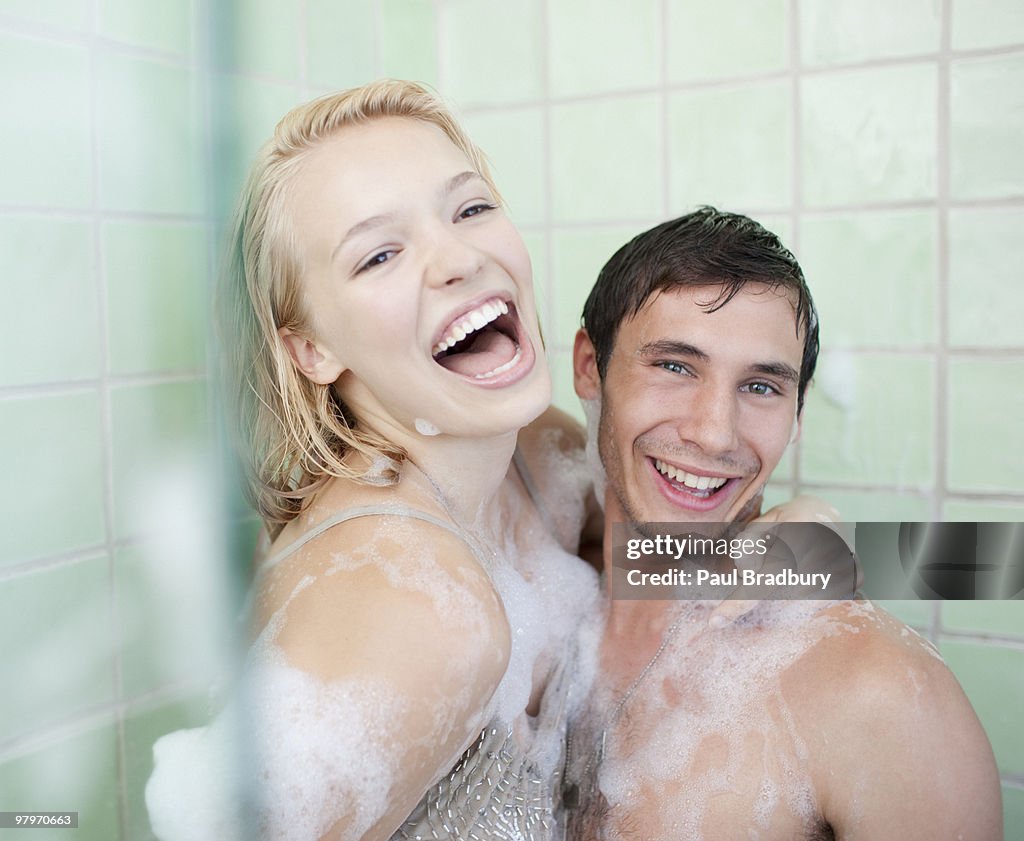 Couple in bathtub covered with soap suds