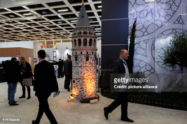 Visitors walk past a miniature model of the Galata Tower of Istanbul at Turkey's hall during the International Tourism trade fair in Berlin, Germany,...