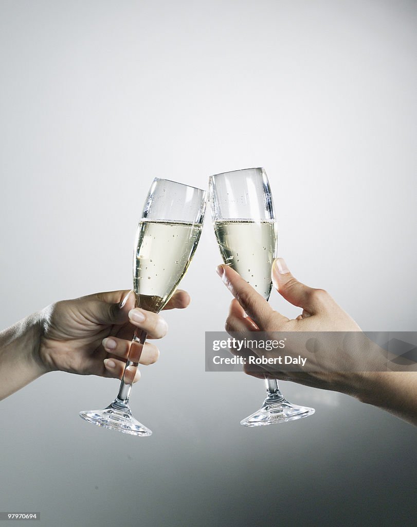 Hände halten und rösten Champagner Flöten