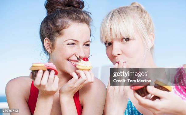 women eating cupcakes - veleiding stockfoto's en -beelden