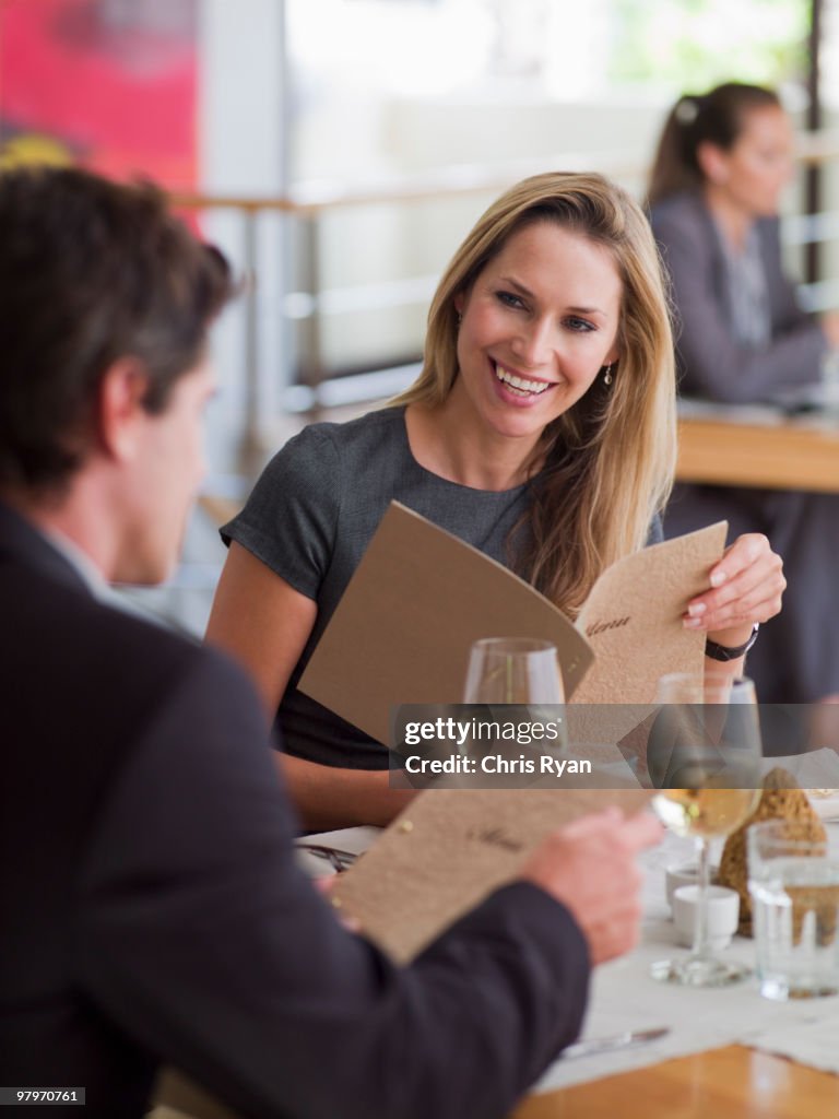 Man and woman looking at menus in restaurant