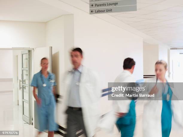 doctors and nurses walking in hospital corridor - hospital blurred motion stock pictures, royalty-free photos & images