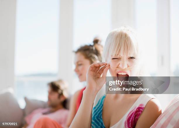 woman making face and holding hair above lip - lip sofa stock pictures, royalty-free photos & images