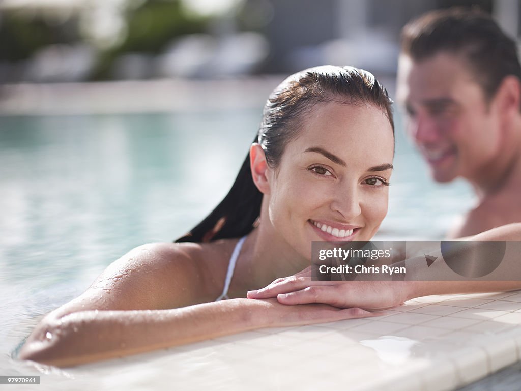 Woman in swimming pool leaning on edge