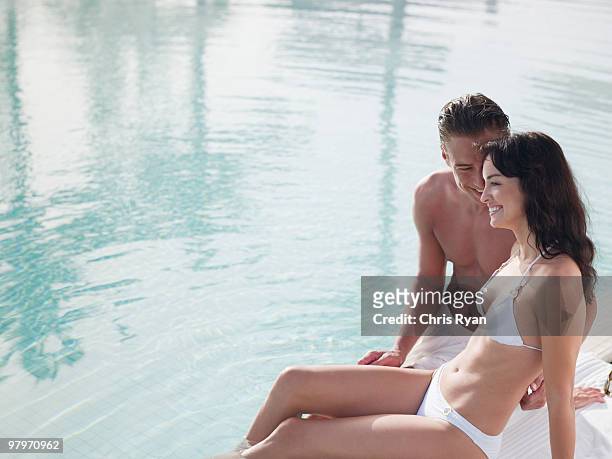 couple sitting at edge of swimming pool - 40 2009 stock pictures, royalty-free photos & images