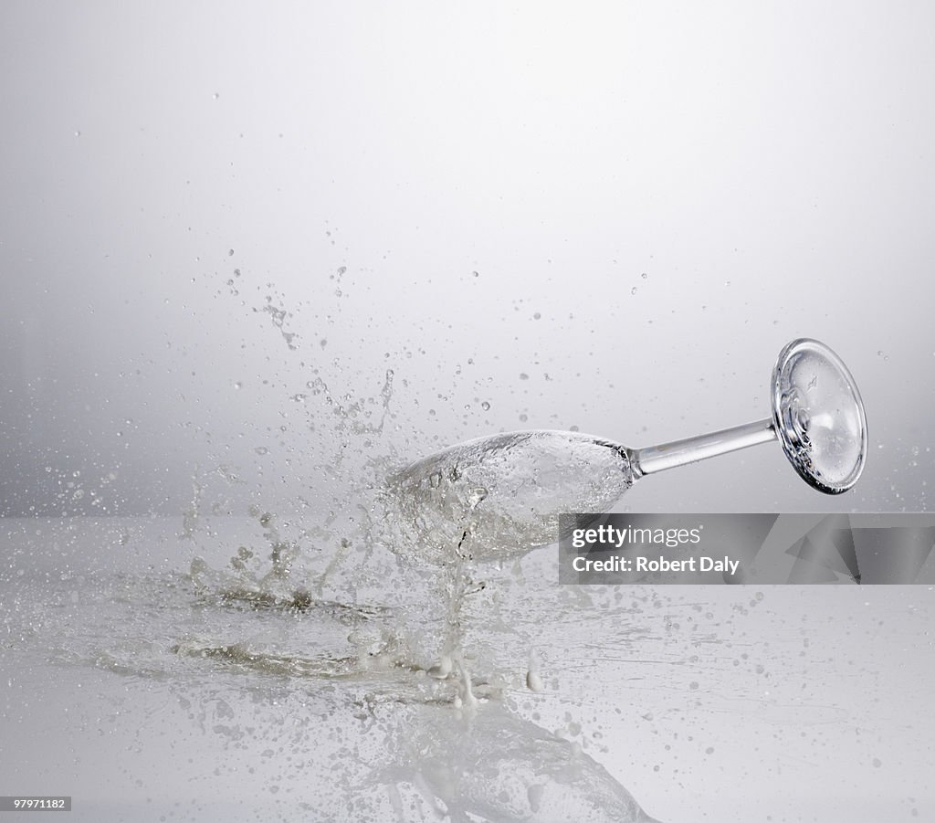 Champagne spilling from falling glass