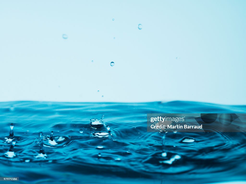 Droplets splashing pool of water