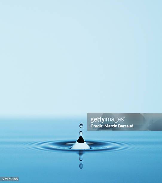 close up of droplet falling in pool of water - water fall stockfoto's en -beelden