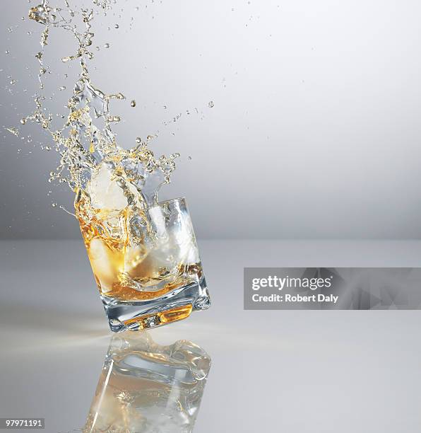 alcohol spilling from highball glass - robert a daly bildbanksfoton och bilder