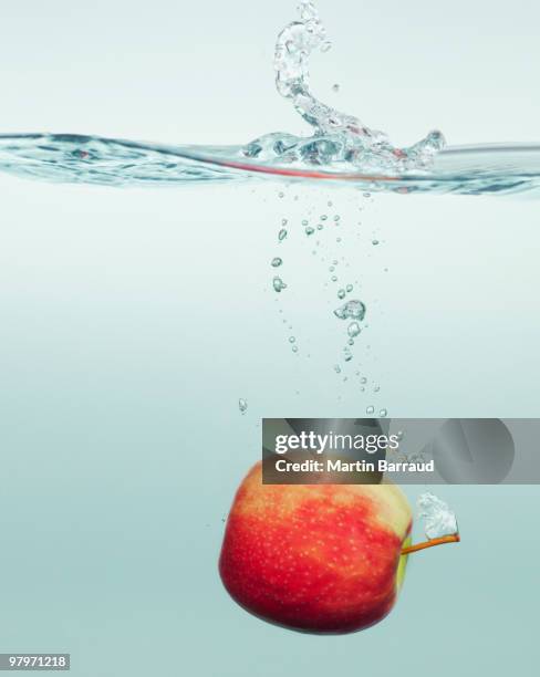 apple splashing in water - apple water splashing stock pictures, royalty-free photos & images