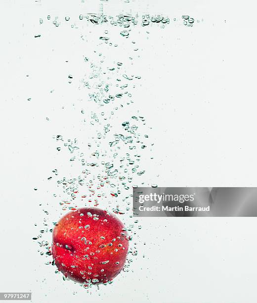 apple splashing in water - sinking stock pictures, royalty-free photos & images